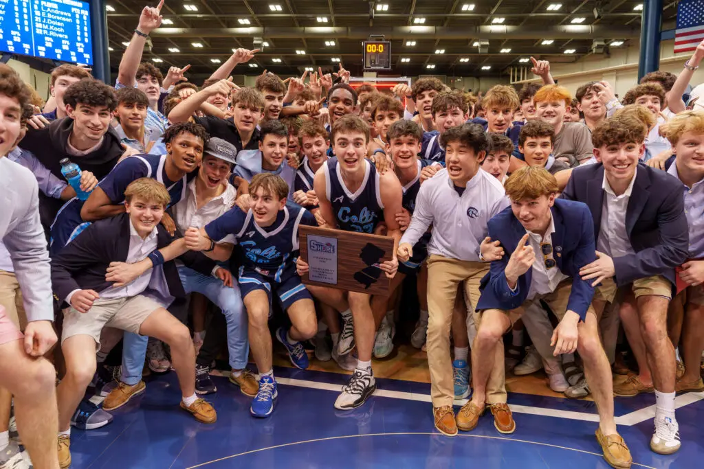 CBA SCT Champs - Shore Sports Insider Connor Andree holds the Shore Conference Tournament trophy surrounded by CBA players and students. (Photo: Patrick Olivero) - CBA SCT Champs