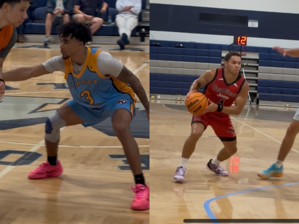 Two basketball players on a court: a defender in a light-blue uniform (#3) crouches left, while an attacker in red carries the ball to drive, with spectators in the background.