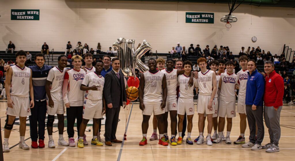 Aidan Saint Louis Ocean 1000 - Shore Sports Insider Aidan Saint Louis (20) celebrates his 1,000th career point with his Ocean Township teammates and coaches. (Photo provided by Ocean Boys Basketball) - Aidan Saint Louis Ocean 1000