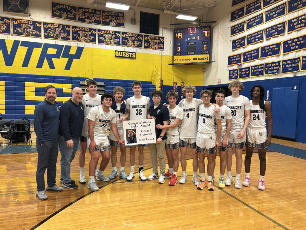Nolan Arnold (32) celebrates breaking New Egypt's all-time scoring record with his teammates and coaches. (Photo provided by New Egypt Boys Basketball) - New Egypt Nolan Arnold