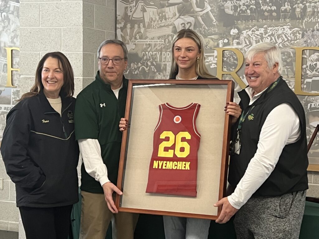 Addy Nyemchek with her McDonald's All-American jersey and coaches. From left: Assistant Kathy Foos, head coach Joe Montano, assistant Joe Pingitore. (Photo: Matt Manley) - Nyemchek All-American